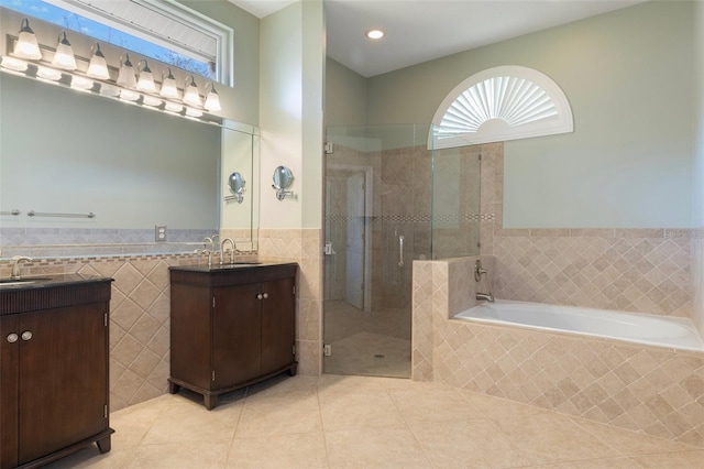 bathroom with vanity, a garden tub, a stall shower, tile patterned floors, and tile walls