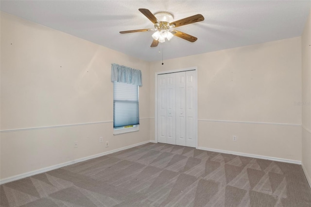 unfurnished bedroom featuring a closet, carpet flooring, ceiling fan, and baseboards