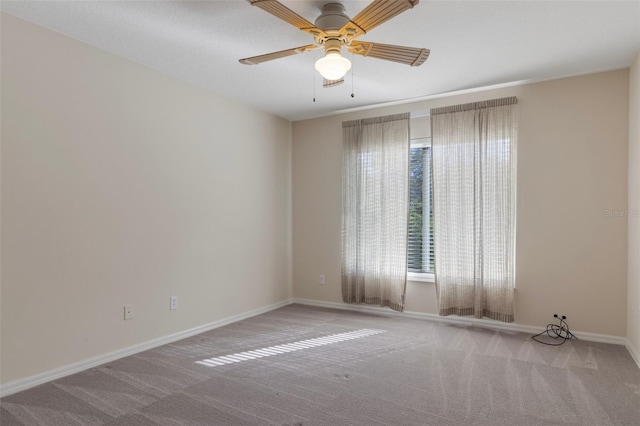 carpeted empty room with baseboards and ceiling fan