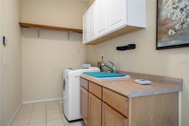 laundry room with light tile patterned floors, baseboards, cabinet space, and independent washer and dryer