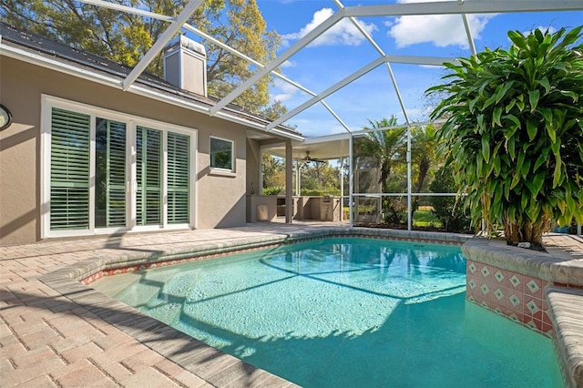 pool with glass enclosure and a patio area