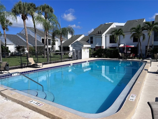 pool featuring a patio area, fence, and a residential view