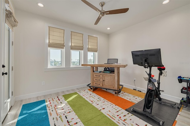 workout area featuring recessed lighting, baseboards, and light wood-style flooring