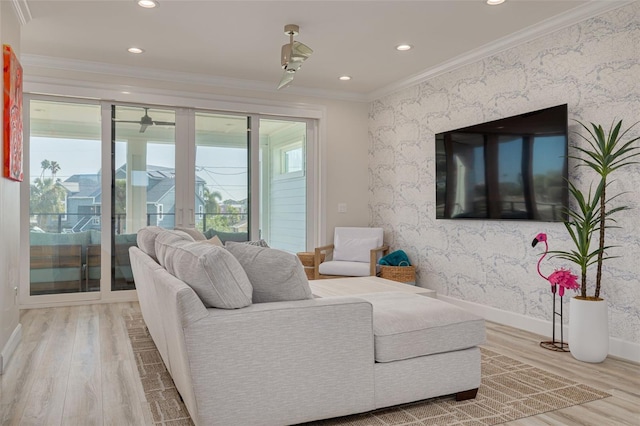 living area with baseboards, wood finished floors, crown molding, and wallpapered walls