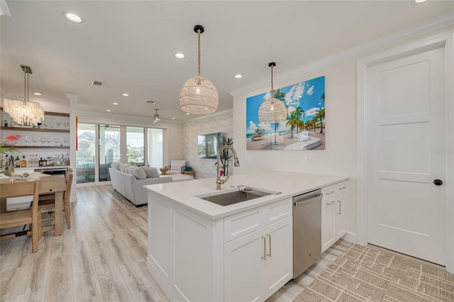 kitchen with visible vents, a sink, stainless steel dishwasher, white cabinetry, and crown molding