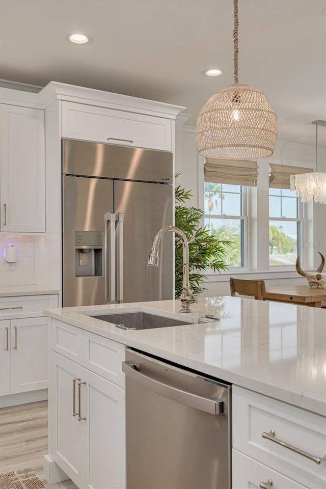 kitchen featuring a sink, stainless steel appliances, decorative backsplash, and white cabinetry