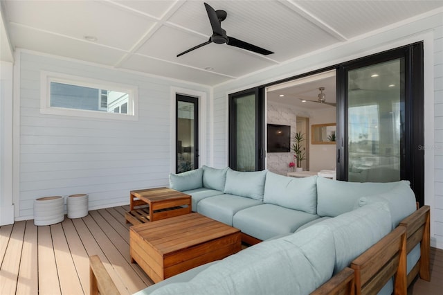 wooden terrace with a ceiling fan and outdoor lounge area