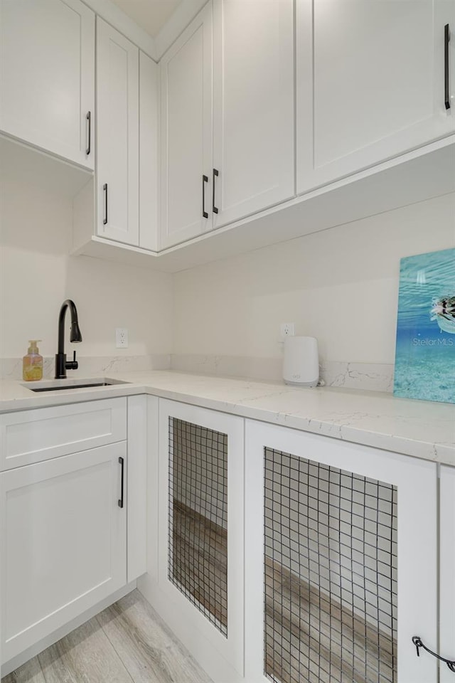 washroom featuring light wood finished floors and a sink