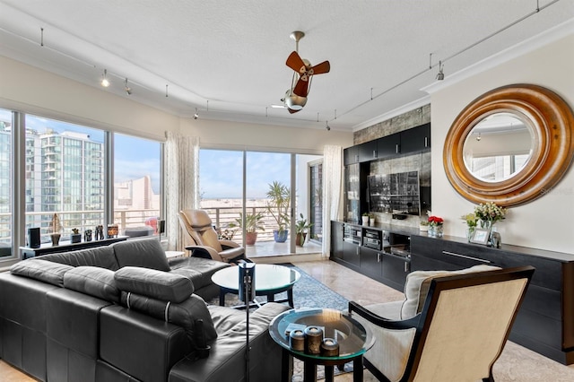 living room featuring rail lighting, ornamental molding, and ceiling fan