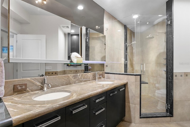 full bath with double vanity, recessed lighting, a stall shower, and a sink