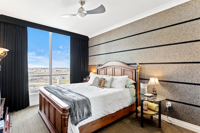 bedroom with a city view, ornamental molding, a ceiling fan, wood finished floors, and baseboards