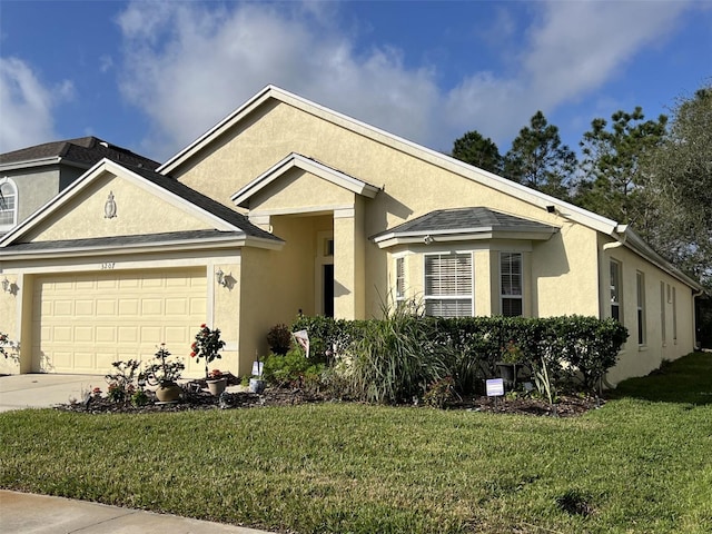 view of front of home with stucco siding, concrete driveway, and a front lawn