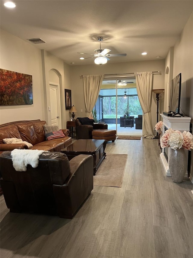 living area featuring visible vents, recessed lighting, wood finished floors, arched walkways, and a ceiling fan