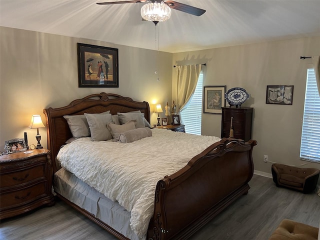 bedroom featuring ceiling fan, baseboards, and wood finished floors