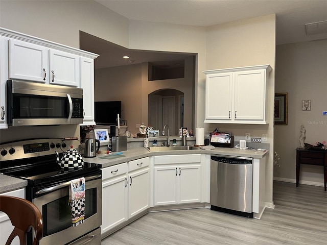 kitchen with stainless steel appliances, white cabinetry, and light countertops