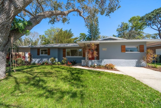 single story home featuring stucco siding, concrete driveway, and a front yard