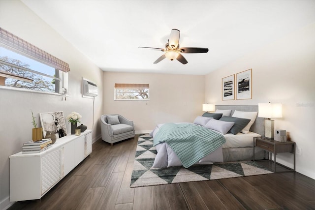 bedroom featuring ceiling fan, baseboards, wood finished floors, and a wall mounted AC