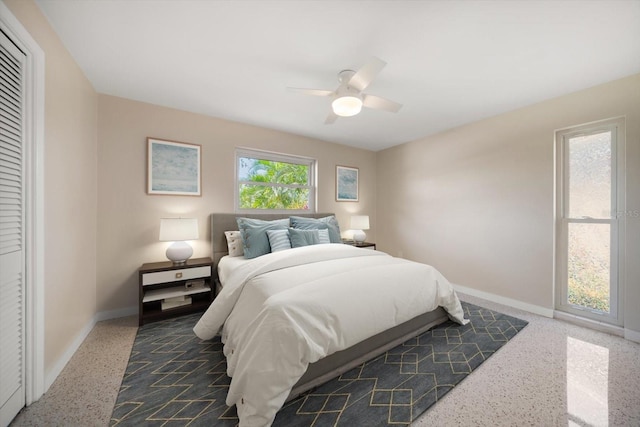 bedroom with a ceiling fan, speckled floor, and baseboards