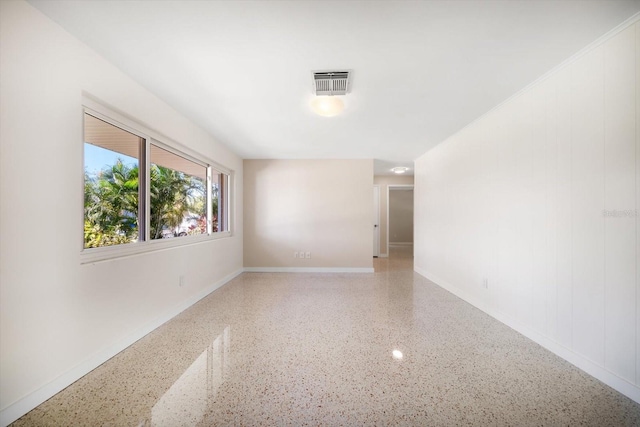 spare room featuring speckled floor, baseboards, and visible vents