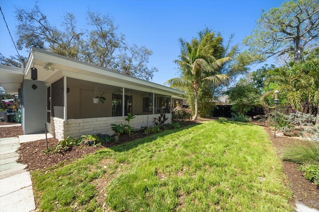 view of yard with fence, a ceiling fan, and a sunroom