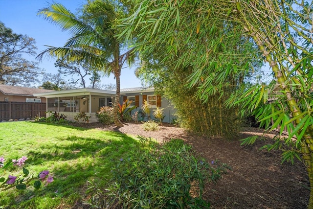 view of yard with a sunroom and fence