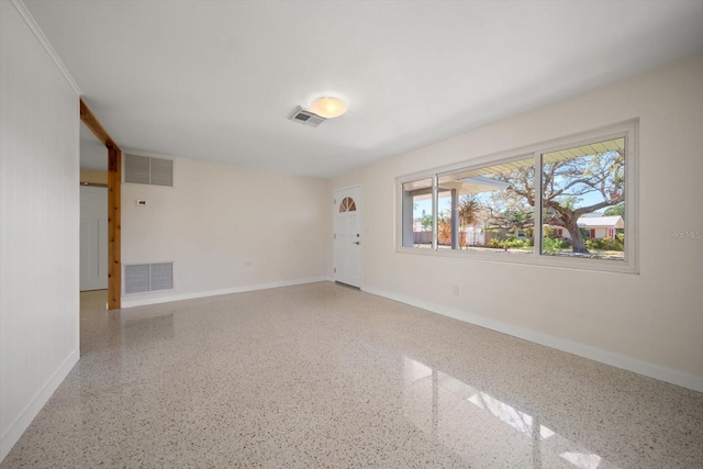 empty room featuring visible vents and speckled floor