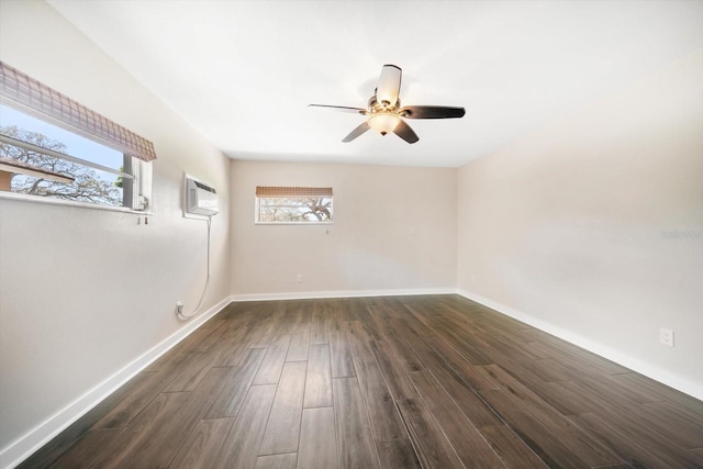 unfurnished room featuring dark wood finished floors, baseboards, and a wall mounted AC