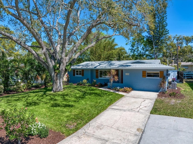 ranch-style house with a front yard, brick siding, driveway, and stucco siding