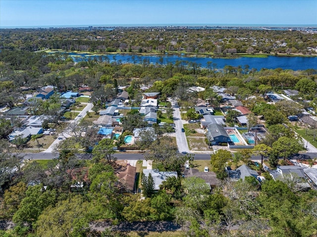 aerial view with a wooded view and a water view