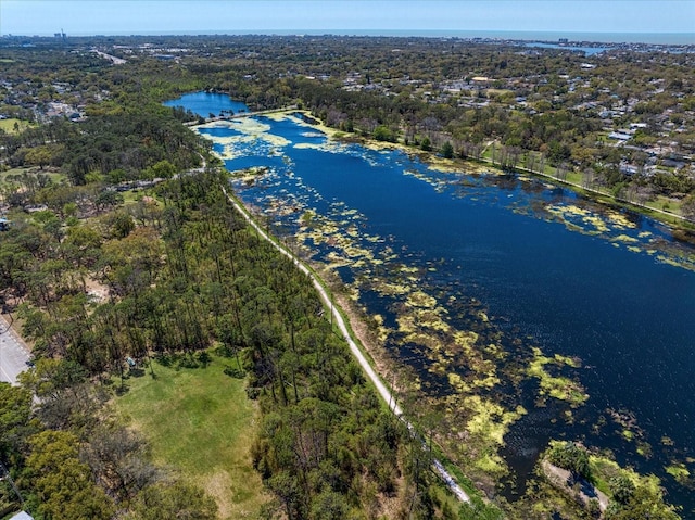 birds eye view of property with a wooded view and a water view