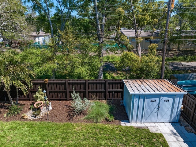 view of yard featuring an outbuilding, a storage shed, and a fenced backyard