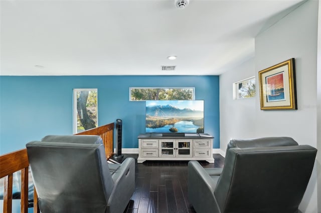 cinema room with dark wood finished floors, visible vents, and baseboards