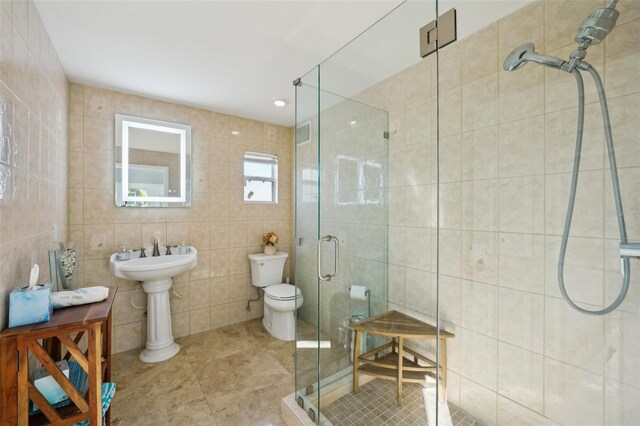 bathroom featuring tile patterned flooring, a shower stall, tile walls, and toilet