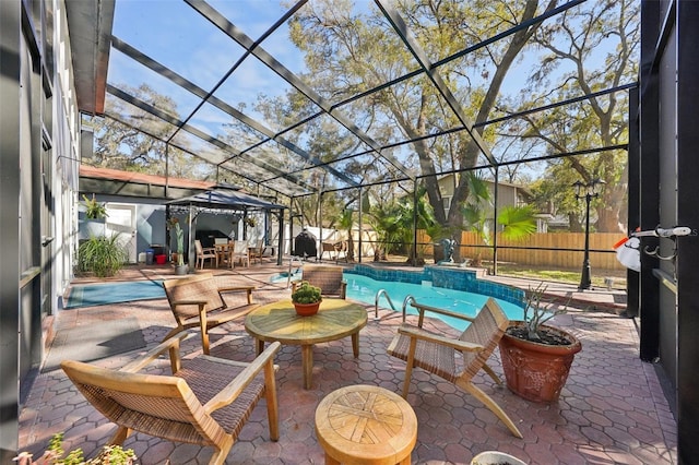 view of patio / terrace featuring a gazebo, glass enclosure, and a fenced backyard