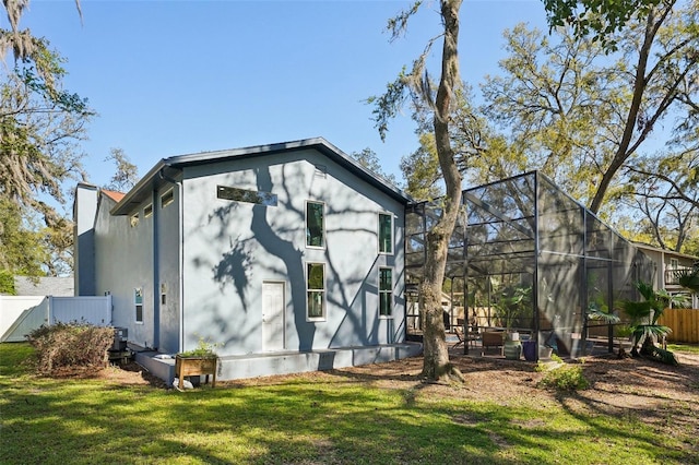 view of home's exterior with fence, central air condition unit, glass enclosure, a lawn, and a patio