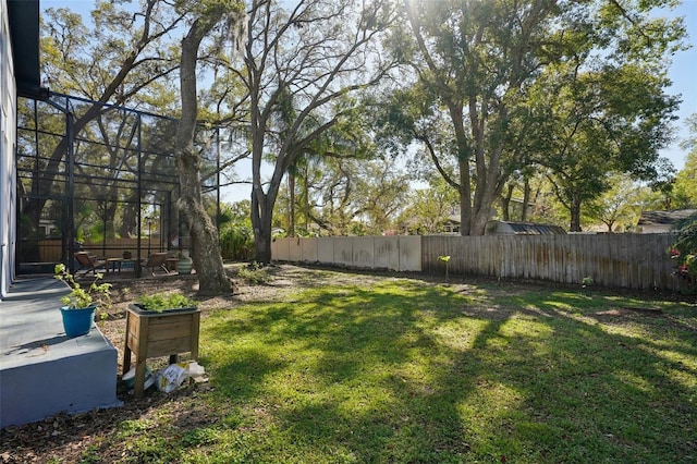 view of yard featuring a lanai and fence