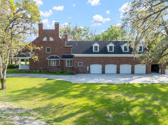 view of front of property featuring a garage, driveway, brick siding, and a front lawn