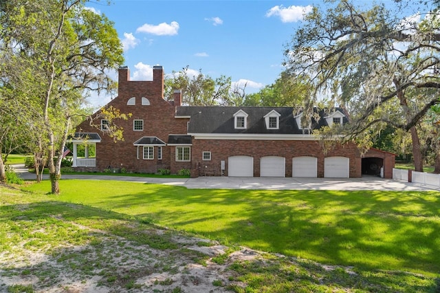 view of front of home with a garage, driveway, brick siding, and a front lawn