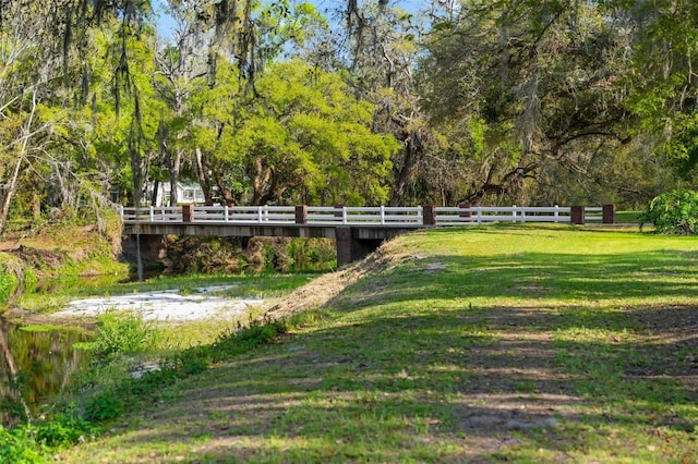 view of community with a wooded view and a yard