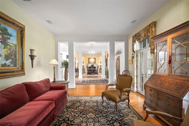 living area featuring a notable chandelier, baseboards, and wood finished floors