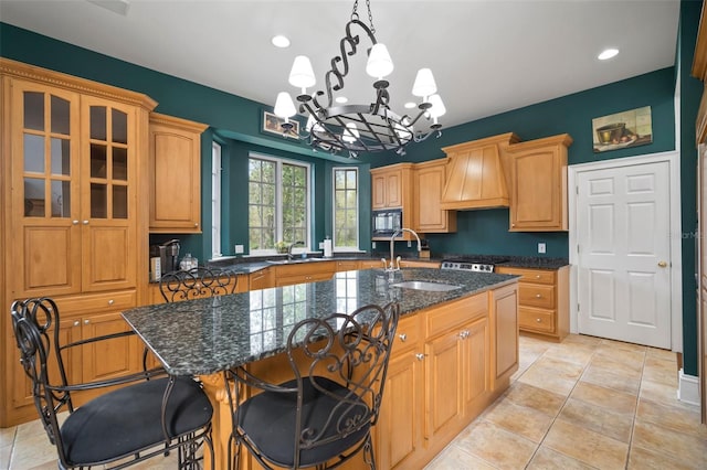 kitchen with custom range hood, a sink, dark stone countertops, a kitchen breakfast bar, and black microwave