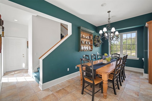 dining space with light tile patterned floors, stairway, an inviting chandelier, and baseboards