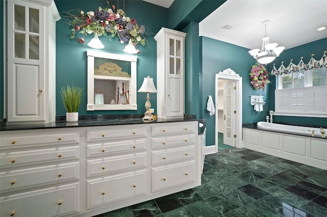 full bath featuring visible vents, a garden tub, marble finish floor, a chandelier, and vanity