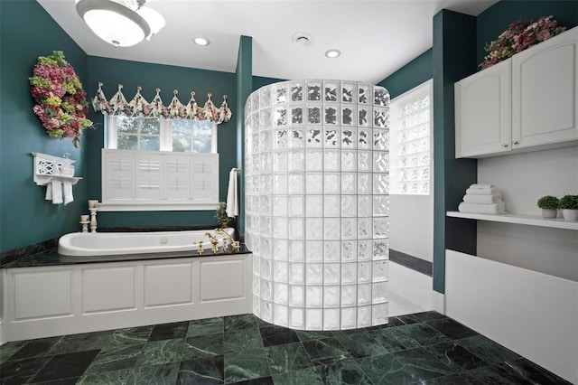 bathroom featuring recessed lighting, a bath, and a walk in shower