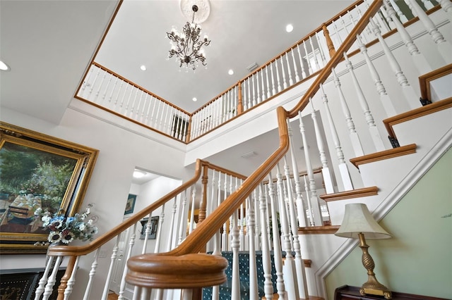 stairs with a high ceiling, recessed lighting, and a chandelier