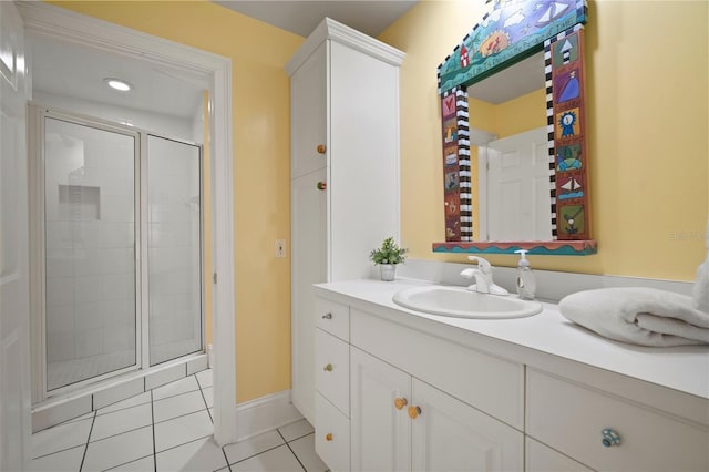 bathroom with tile patterned floors, a stall shower, vanity, and baseboards