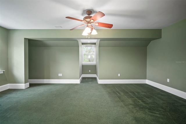 additional living space with a ceiling fan, baseboards, and dark colored carpet