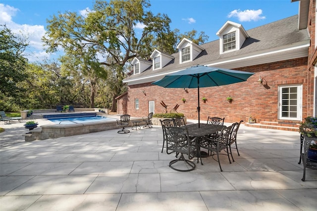 view of patio with an outdoor pool, entry steps, outdoor dining area, and an in ground hot tub