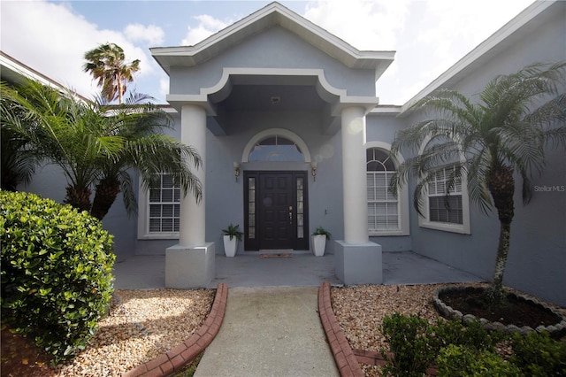 doorway to property featuring stucco siding