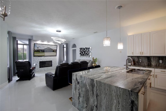 dining space featuring a large fireplace and an inviting chandelier